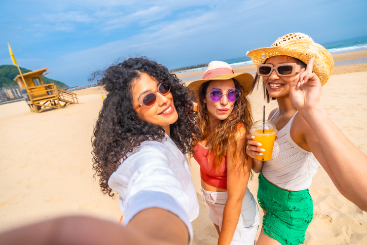 Three women are posing for a picture on the beach | Glam(グラム)