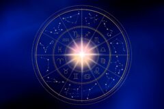 Circular golden zodiac wheel with zodiac symbols, constellations, and a glowing center on a dark blue background.