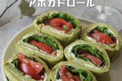 Five avocado rolls filled with tomato and greens on a white plate; Japanese text reads 'Avocado Roll' overhead.