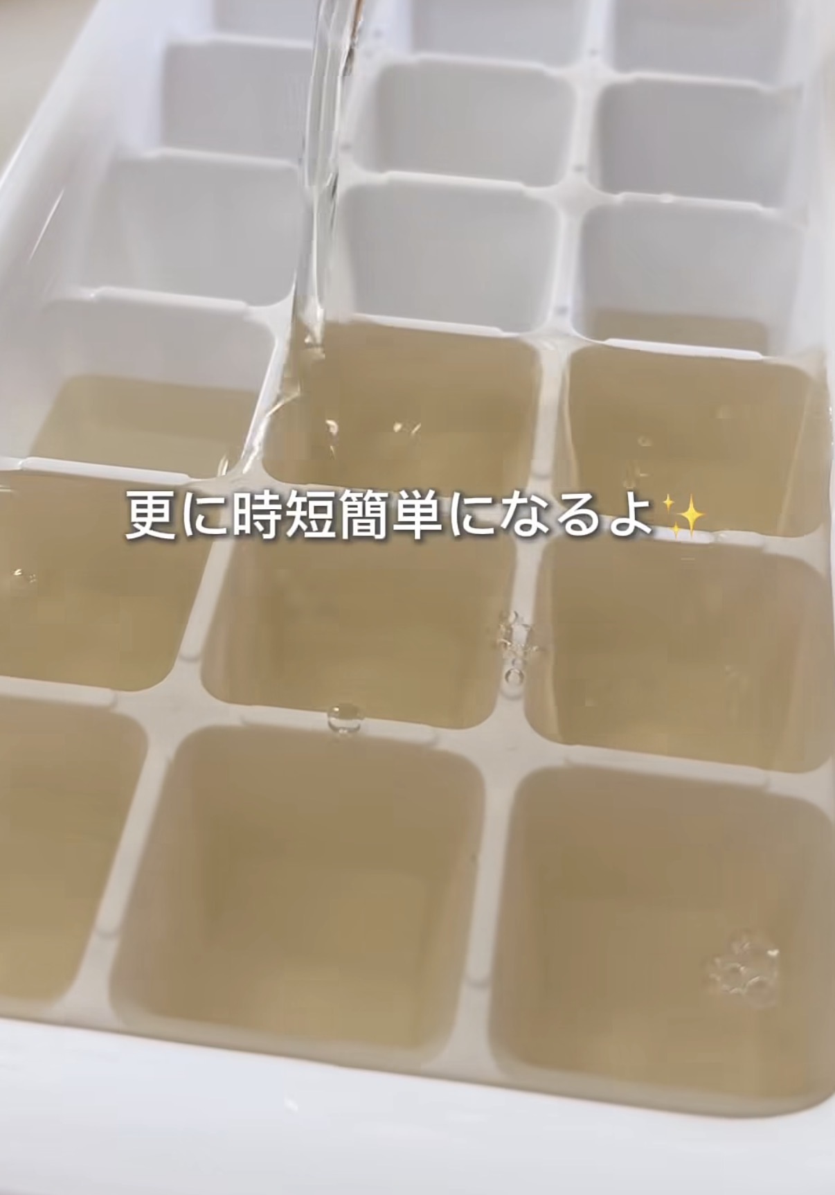 Screenshot | GLAM(グラム)|自分らしく生きる女性に、1日1GLAMを。 Close-up of a white ice cube tray with pale amber liquid filling several compartments, a stream pouring into the tray.